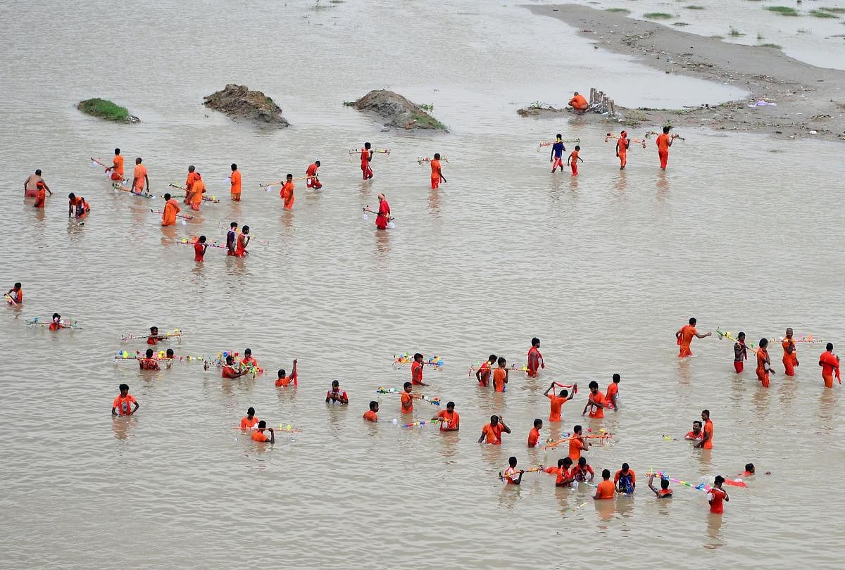 Indian kanwariya, devotees of the Hindu deity Shiva, collect water from the Ganges river for their ritualistic walk towards Varanasi during the holy month of Shravan, in Allahabad (AFP Photo)