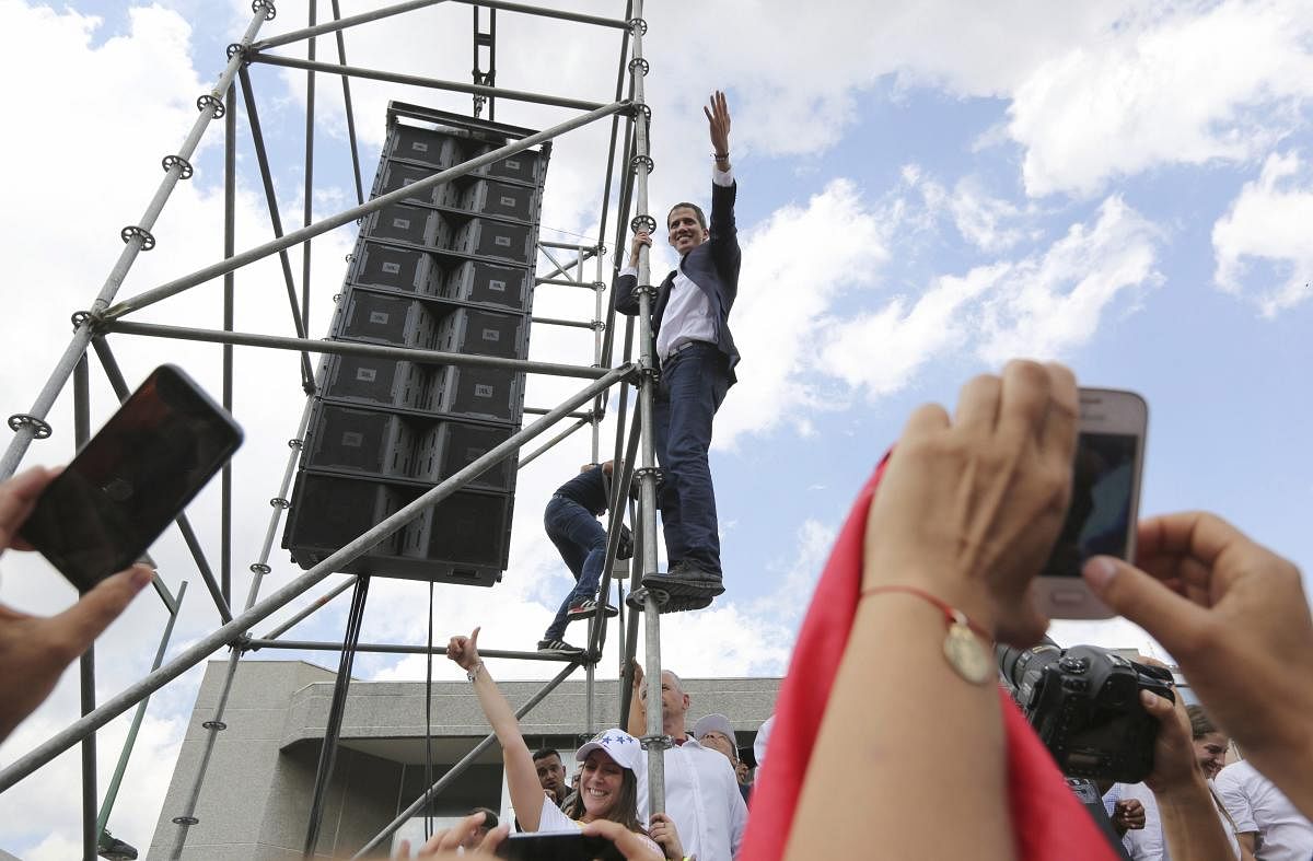 Venezuelan Congress President Juan Guaido, an opposition leader who declared himself interim president, waves from the scaffolding after speaking at a rally demanding the resignation of Venezuelan President Nicolas Maduro in Caracas, Venezuela. AP/PTI
