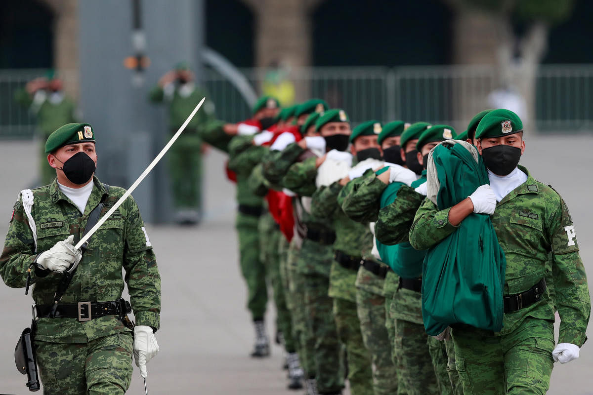 Mexican soldiers wearing protective face masks take part in a daily ceremony to lower the Mexican flag as the outbreak of the coronavirus disease (COVID-19) continues in Mexico City, Mexico. Credit: Reuters Photo