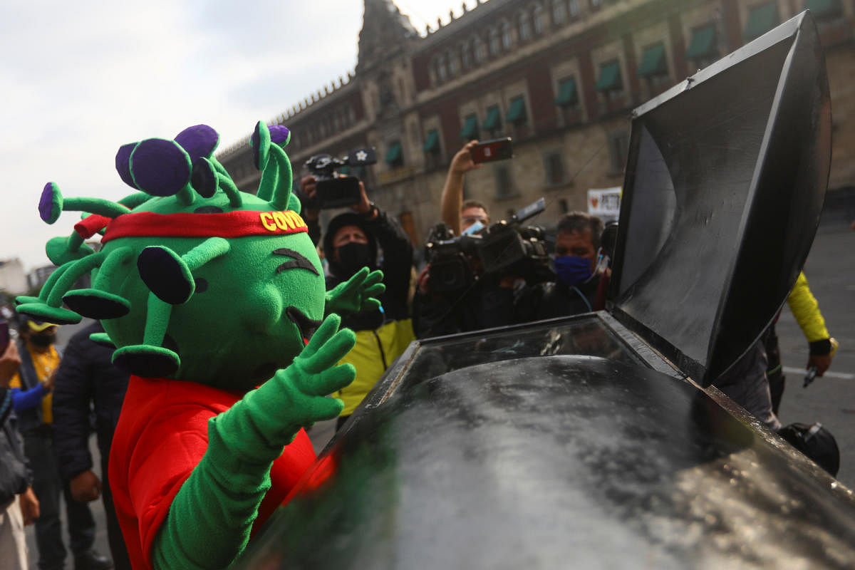 An activist in a costume gestures to a symbolic coffin outside the National Palace to demand the release of inmates serving ordinary sentences in the jails, as the outbreak of the coronavirus disease (COVID-19) continues, in Mexico City, Mexico. Credit: Reuters Photo