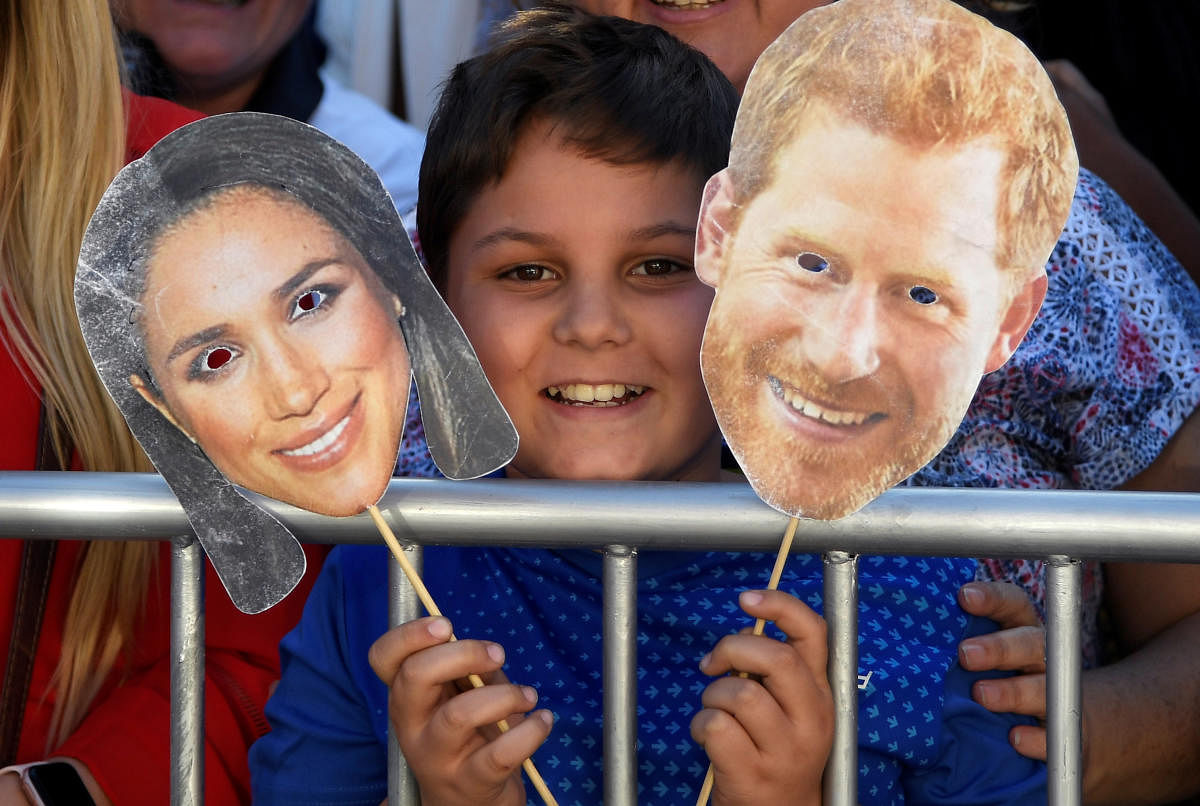 A boy holds the masks of Prince Harry and his wife Meghan, the Duke and Duchess of Sussex, before their arrival to the District Six Museum, on the first day of their African tour in Cape Town, South Africa, September 23, 2019. REUTERS/Toby Melville