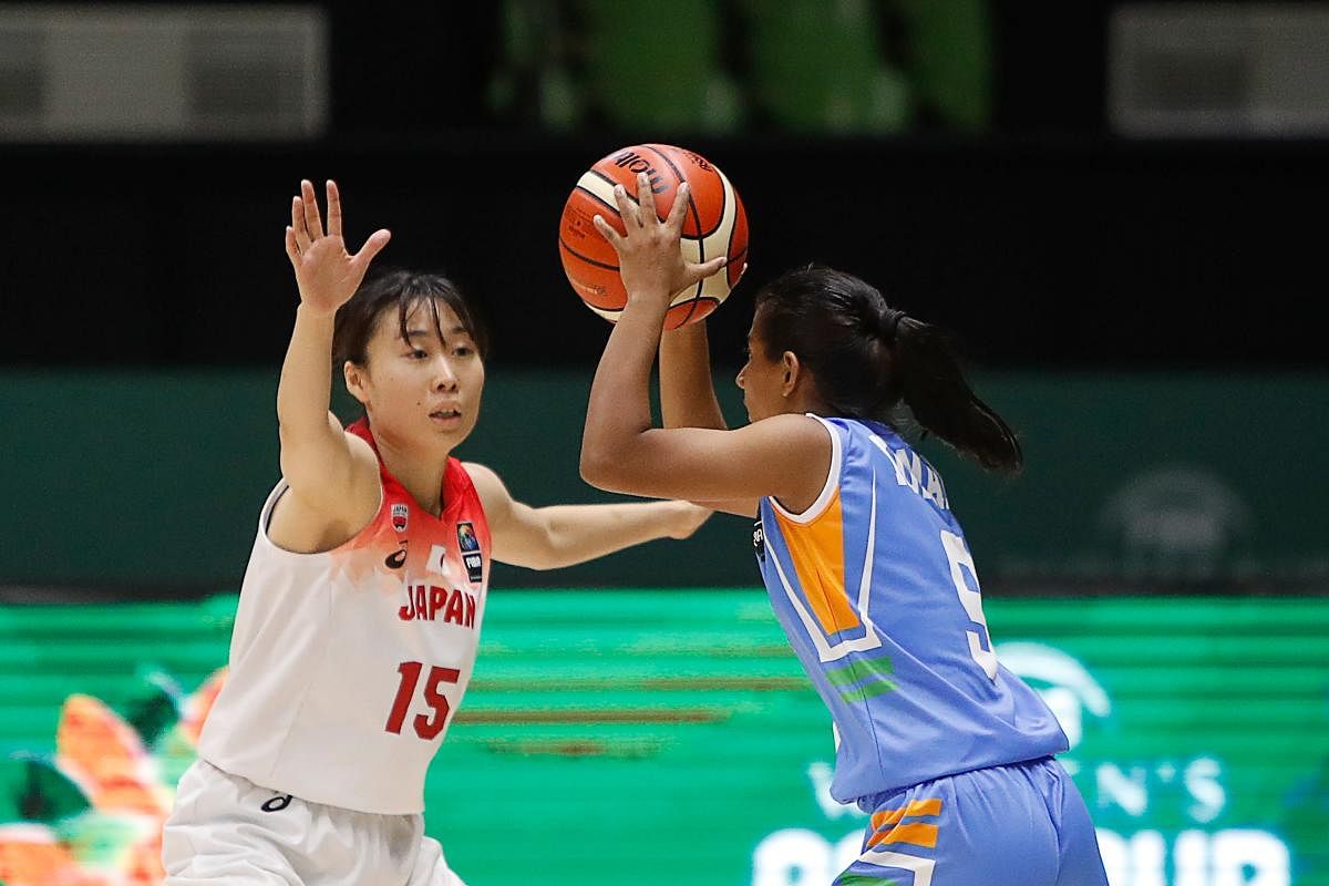 Japan's Nako Motohashi (L) attempts to stop the ball from India's Madhu Kumari during the 2019 FIBA Women's Asia Cup basketball match between Japan and India in Bangalore on September 24, 2019.  (Photo by Abhishek N. CHINNAPPA / AFP)