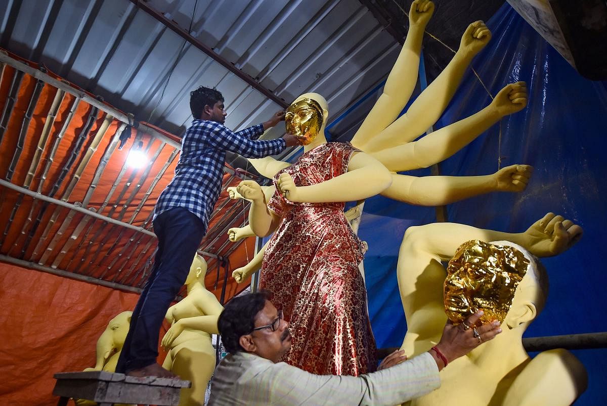 Kolkata: Clay artist Mintu Paul and his associates take measurements to adjust gold mask on the clay idol of Goddess Durga at a workshop before being transported to a community pandal, ahead of Durga Puja festival in Kolkata, Thursday, Sept. 26, 2019. (PTI Photo/ Swapan Mahapatra)(PTI9_26_2019_000177B)