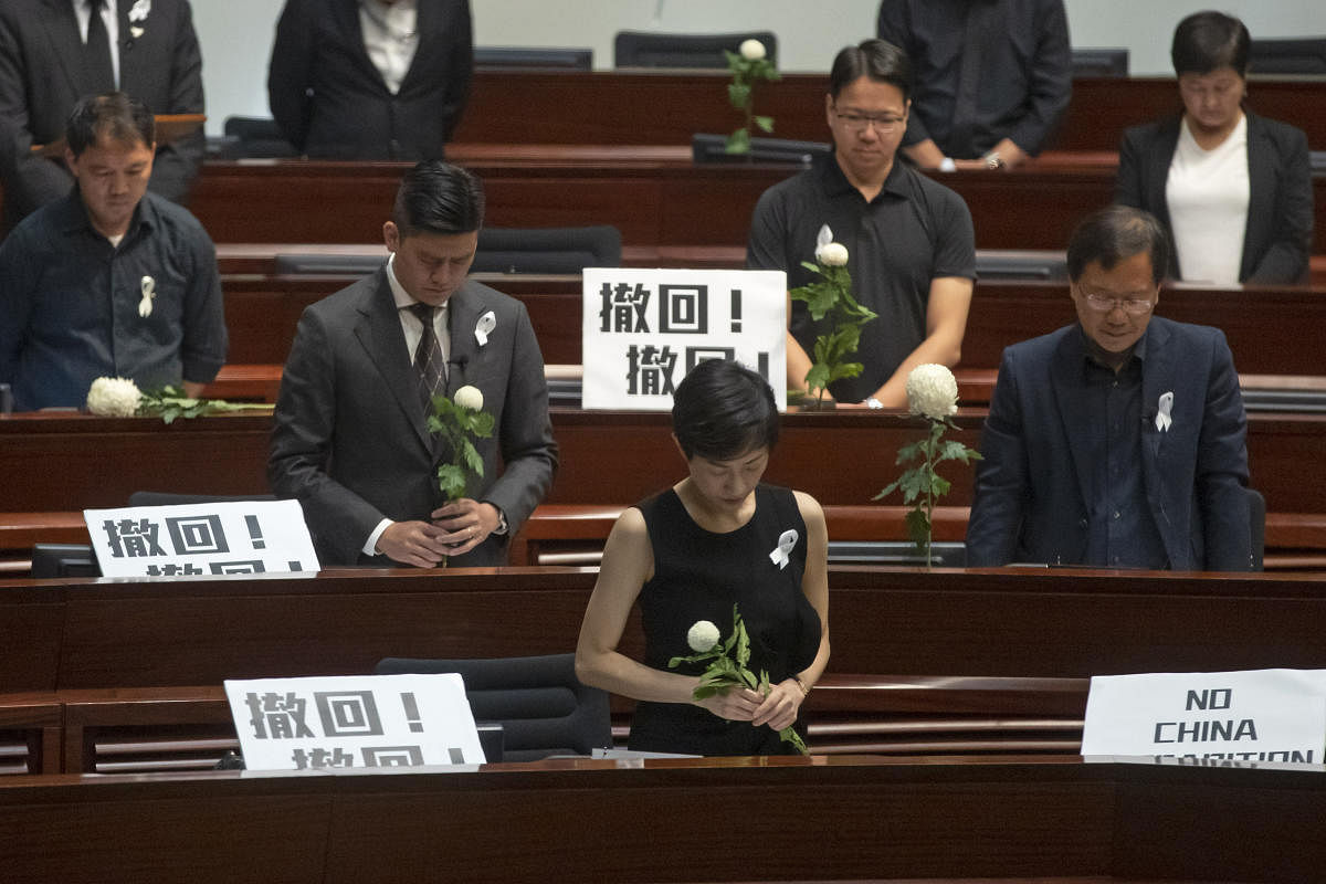 Pro-democracy lawmakers pay a silent tribute to the man who fell to his death on Saturday evening after hanging a protest banner on scaffolding on a shopping mall, at the Legislative Council in Hong Kong, Wednesday, June 19, 2019. AP/PTI