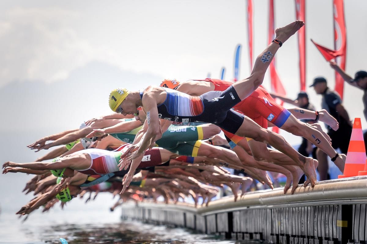 France's Vincent Luis (No1 in Yellow) jumps into Geneva Lake with competitors at the start of the ITU World Triathlon Grand Final on August 31, 2019 (AFP Photo)