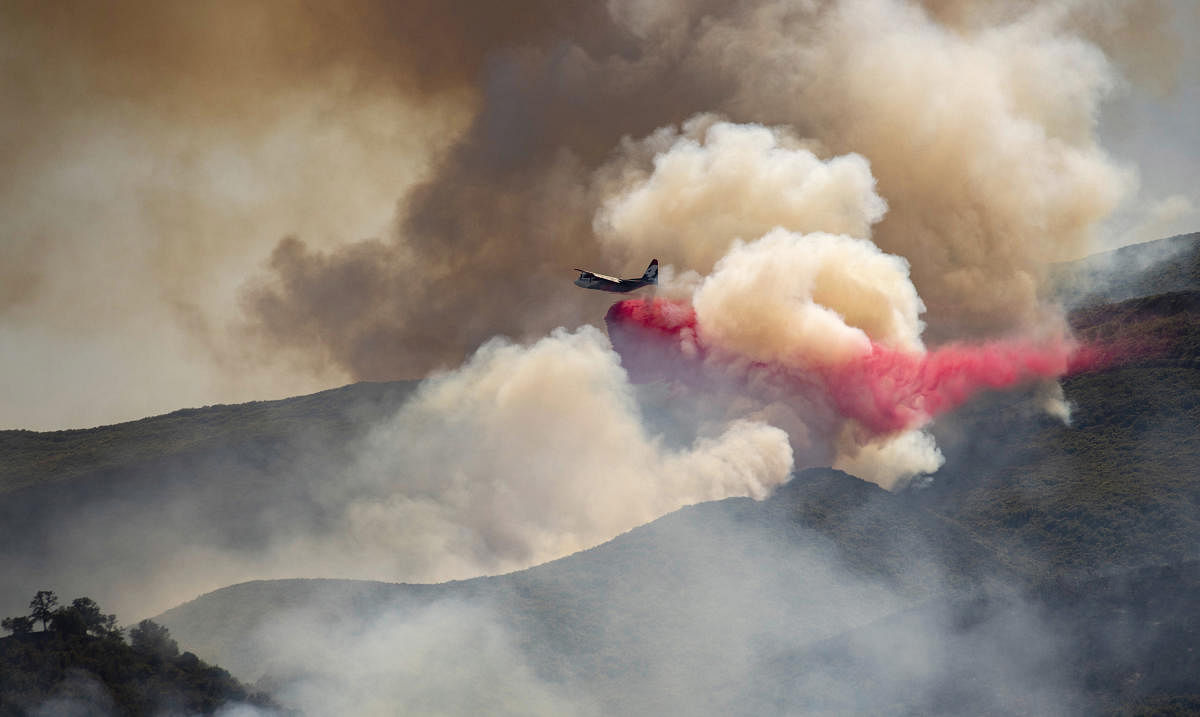 A plane drops fire retardant on a hillside in an attempt to box in flames from a wildfire during the Sand Fire in Rumsey, Calif., Sunday, June 9, 2019. AP/PTI(