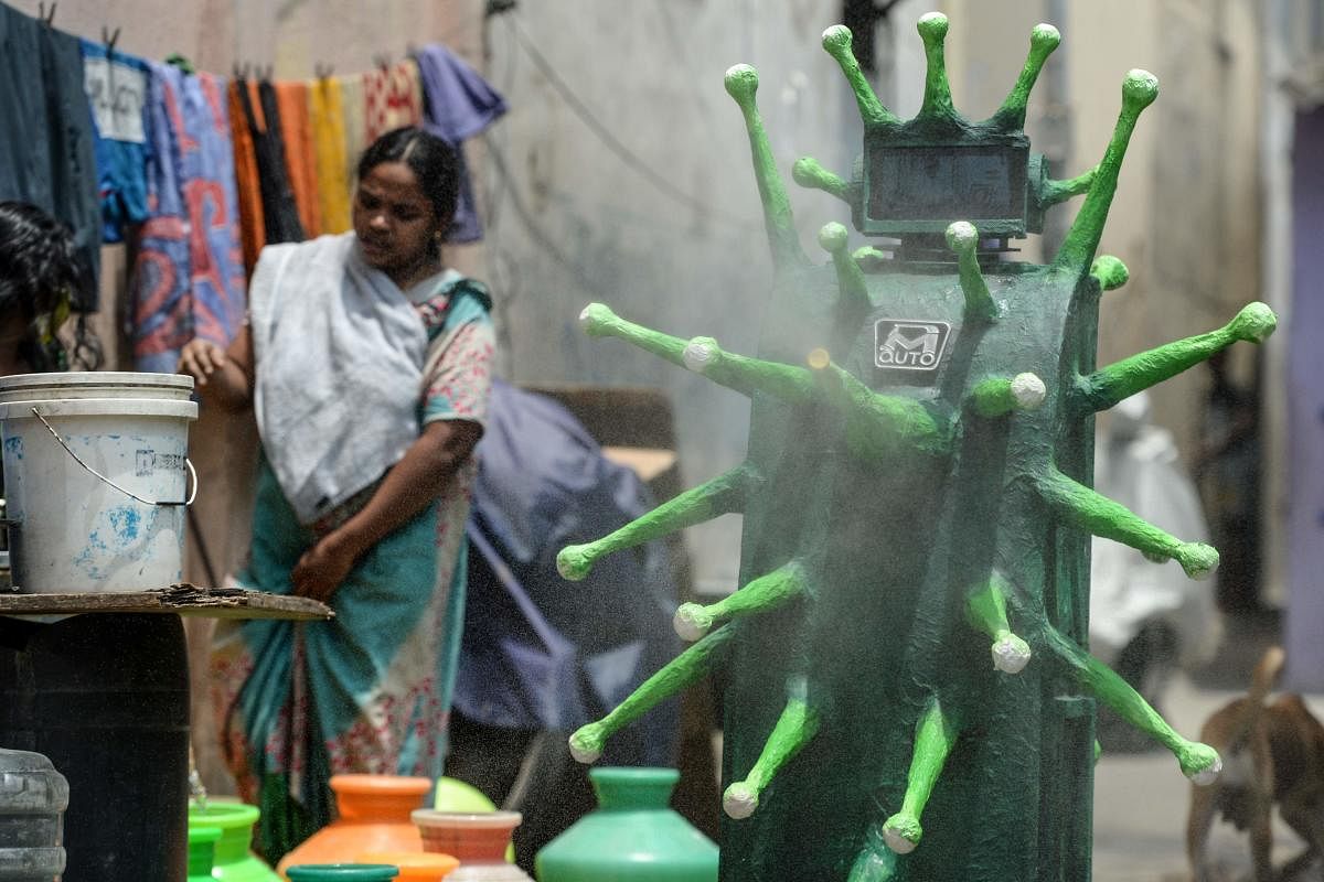 A coronavirus-themed robot navigated by health officials (unseen) sprays disinfectant in a residential area after the government eased a nationwide lockdown imposed as a preventive measure against the COVID-19 coronavirus, in Chennai on May 20, 2020. Credit: AFP Photo