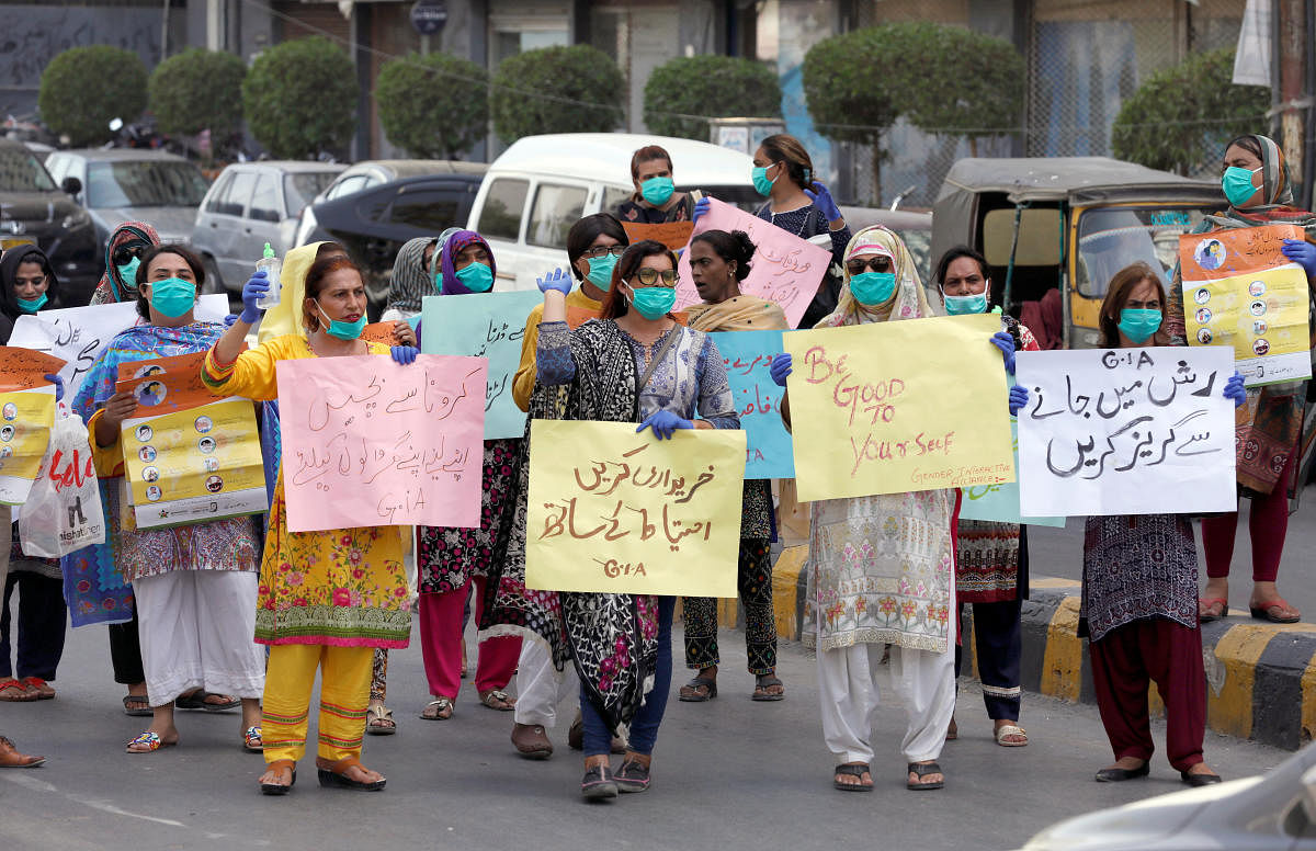Members of the transgender community wear protective masks and gloves as they hold signs during an awareness walk following the coronavirus disease (COVID-19) outbreak, in Karachi, Pakistan May 20, 2020. Credit: Reuters Photo
