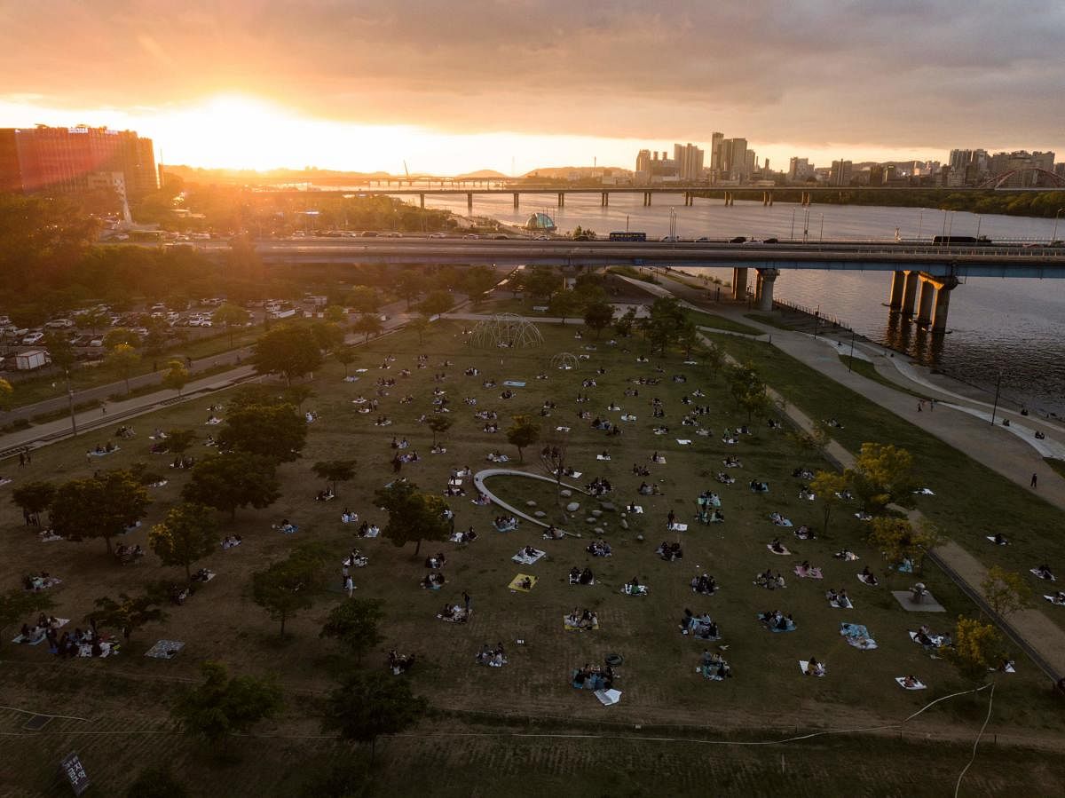 People sit in Yeouido park in central Seoul during sunset on May 20, 2020. Credit: AFP Photo