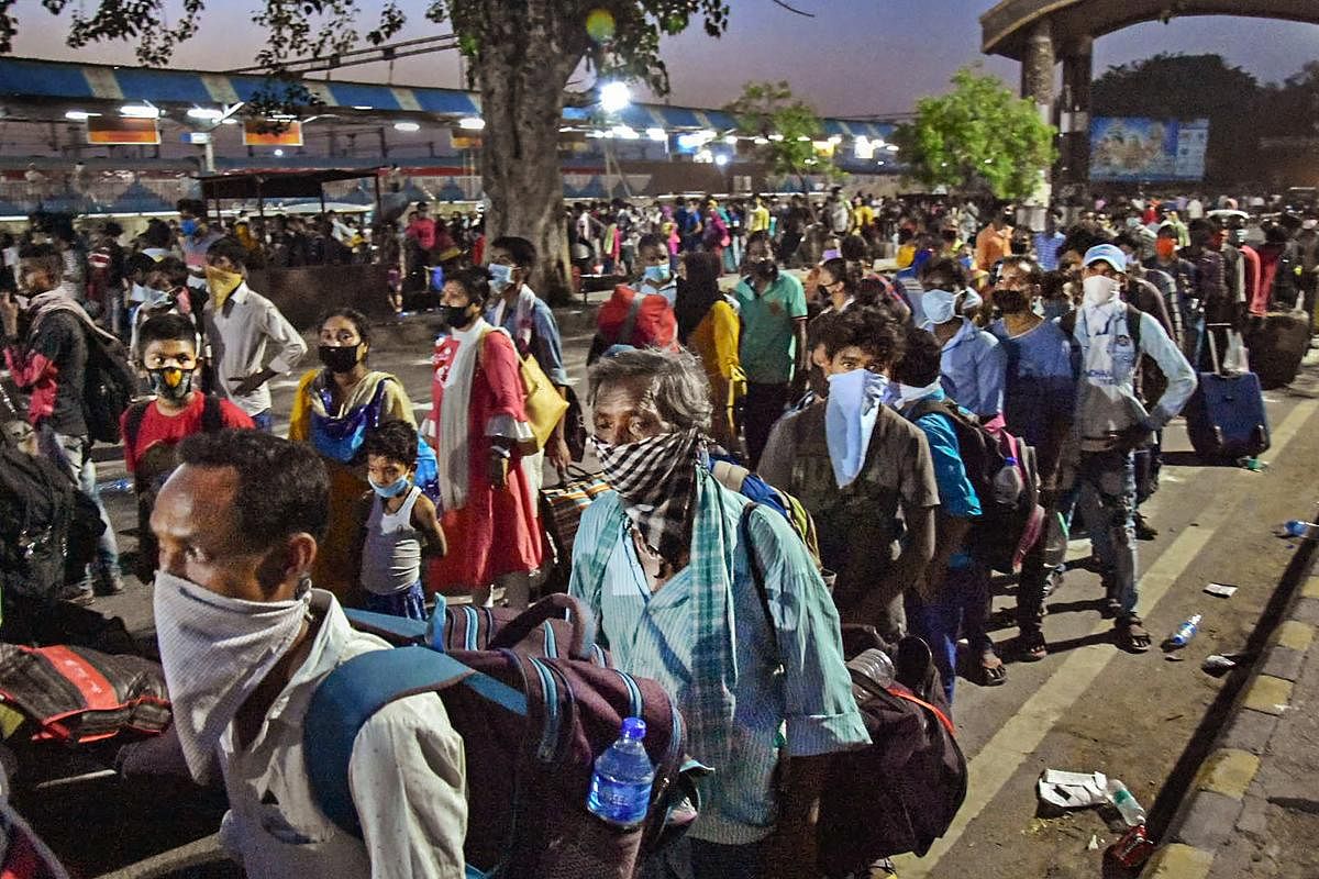 Migrants from West Bengal walk to board a train at Mathura junction, during the ongoing COVID-19 nationwide lockdown, in Mathura. (PTI Photo)