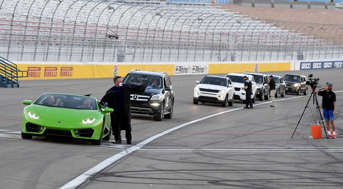 Faith Lutheran High School CEO Steve Buuck gives a diploma to a student driving a Lamborghini during a commencement ceremony for Faith Lutheran held at Las Vegas Motor Speedway due to the spread of the coronavirus in Las Vegas. (AFP Photo)