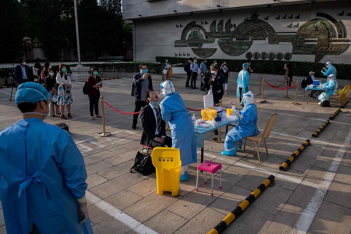 Medical workers wearing full protective gear prepare to take swab samples from journalists to test for the COVID-19 coronavirus, nine hours before the press conference of China's Foreign Minister Wang Yi during the National People's Congress (NPC) in Beijing. (AFP Photo)