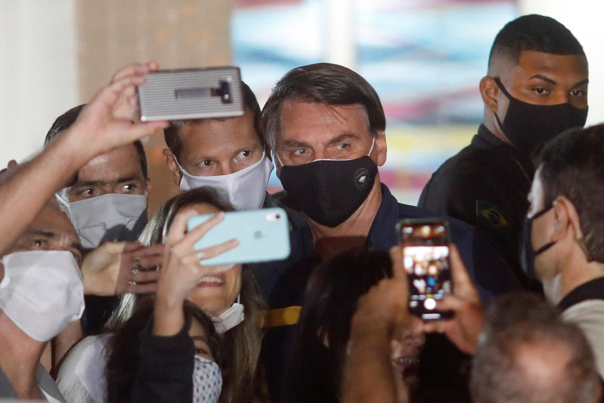 Brazil's President Jair Bolsonaro poses for a picture with supporters amid the coronavirus disease (COVID-19) outbreak, in Brasilia, Brazil. (Reuters photo)