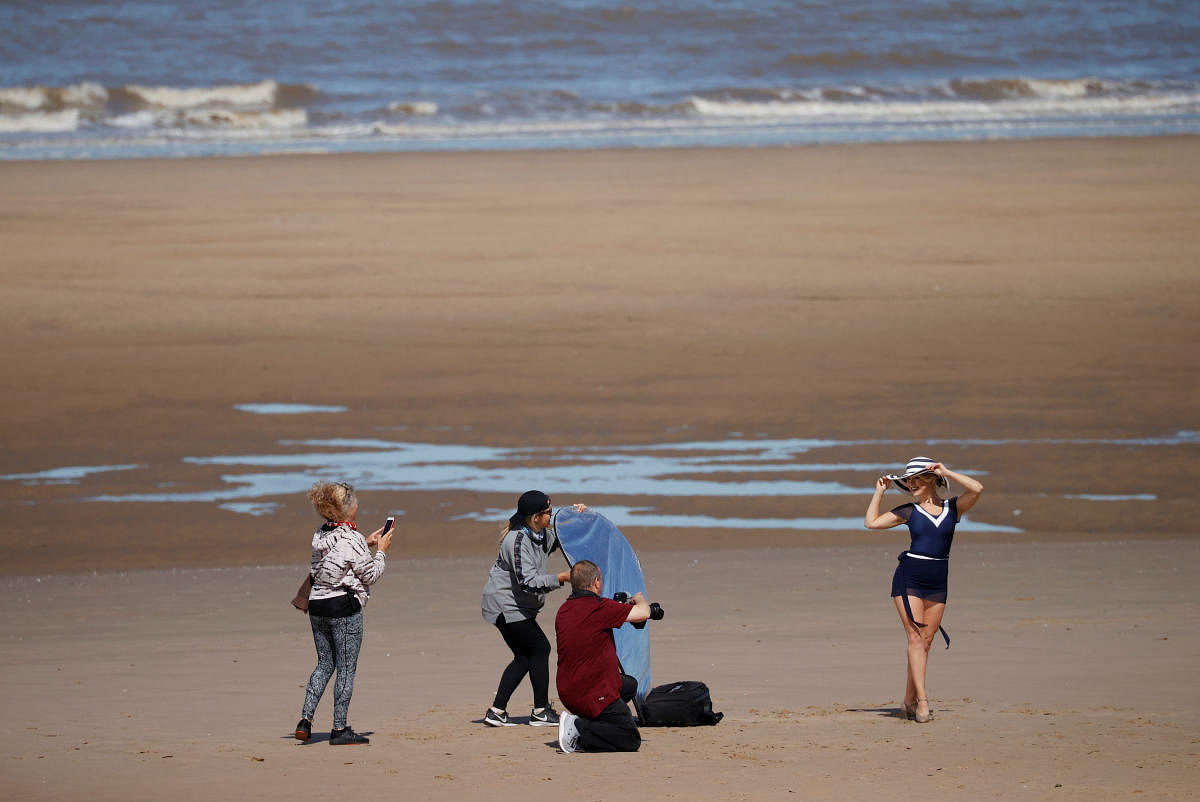A woman is seen posing for photographers on Blackpool beach following the outbreak of the coronavirus disease (COVID-19), Blackpool, Britain, May 25, 2020. (Reuters photo)