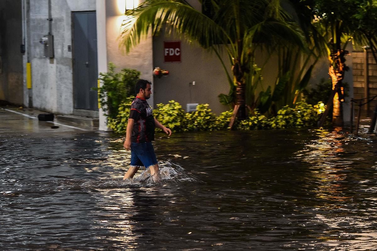 A man walks in flooded water during a heavy rainfall in Miami, on May 26, 2020. (AFP Photo)