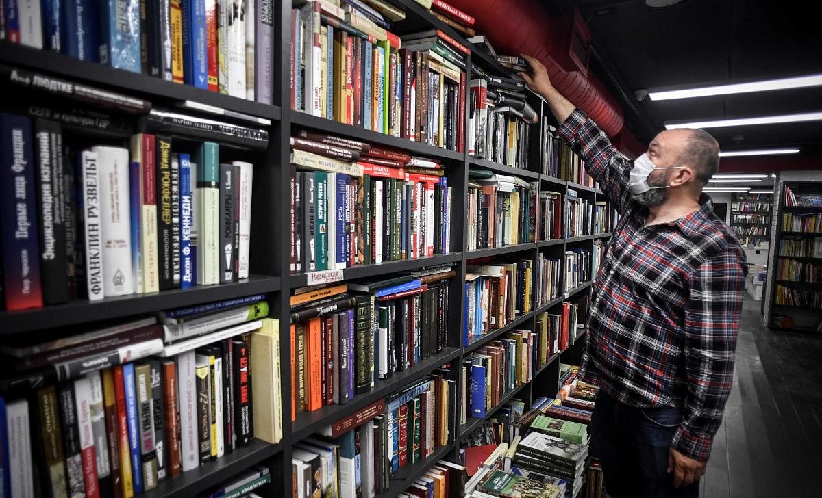Russian businessman Boris Kupriyanov, the owner of Falanster book store, inspects shelves in his closed shop in Moscow on May 29, 2020, amid the COVID-19 outbreak, caused by the novel coronavirus. - When Moscow authorities closed bookshops and other non-essential businesses to stop the spread of the coronavirus, publisher Boris Kupriyanov began to personally deliver books to customers. This, he said, is what has helped him and his indie bookstore to survive for the past two months. (Photo by AFP)