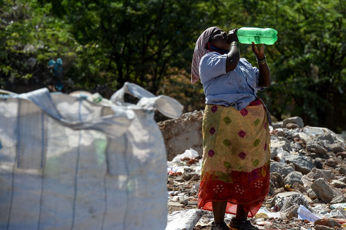 A woman drinks water as she collects recyclable items at a garbage dump site on the outskirts of Hyderabad on the United Nations' World Environment Day. (PTI Photo)