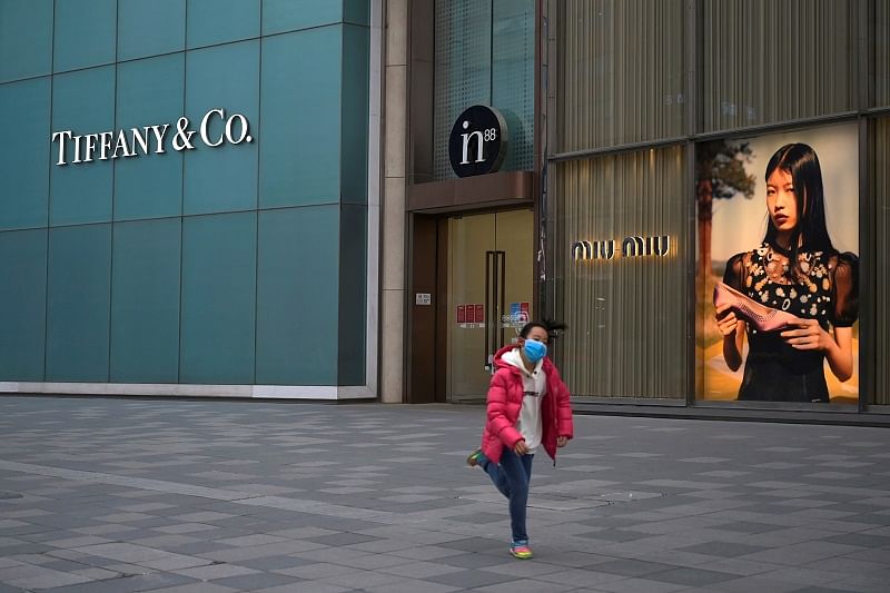 A child wearing a face mask runs past stores of Tiffany & Co and Miu Miu, as the country is hit by an outbreak of the novel coronavirus, in Beijing, China. (Reuters Photo)