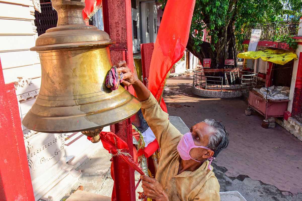 A worker cleans a bell at Goddess Khermai temple, ahead of its re-opening, during the ongoing COVID-19 lockdown, in Jabalpur. PTI Photo