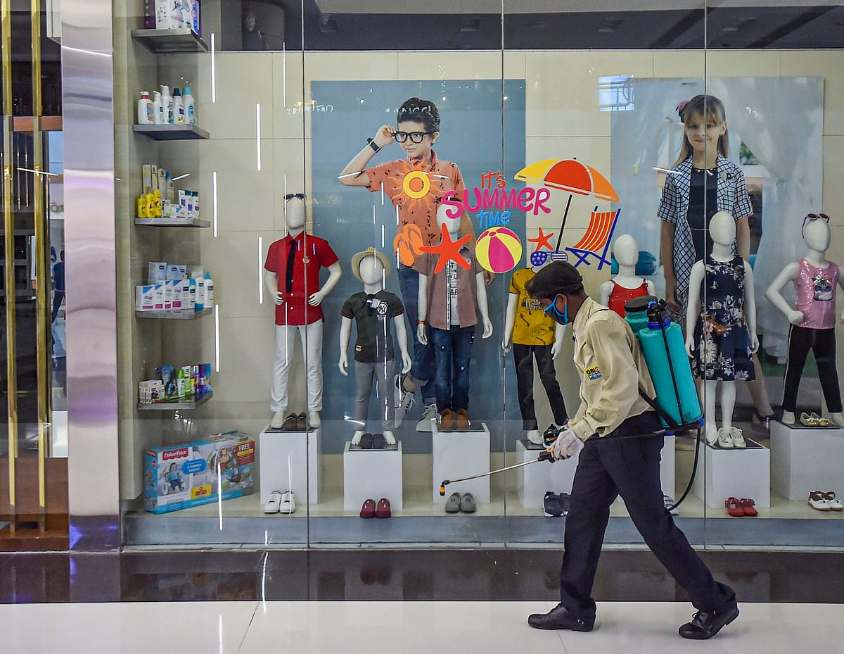 A worker sprays disinfectant inside a shopping mall ahead of its reopening during the fifth phase of nationwide COVID-19 lockdown, in Kolkata. PTI Photo