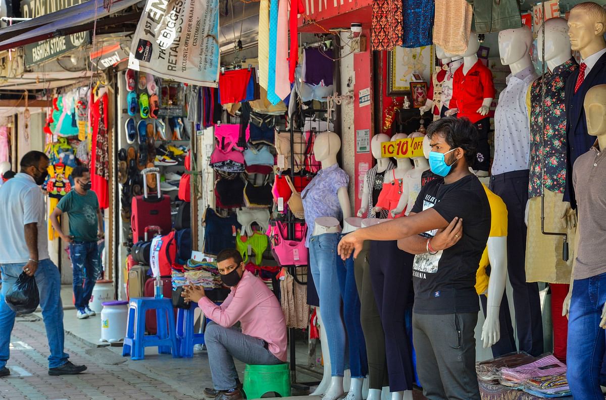 Salesmen, wearing face masks, wait for customers at the Sarojini Nagar market, during ongoing COVID-19 lockdown, in New Delhi. Credit: PTI Photo
