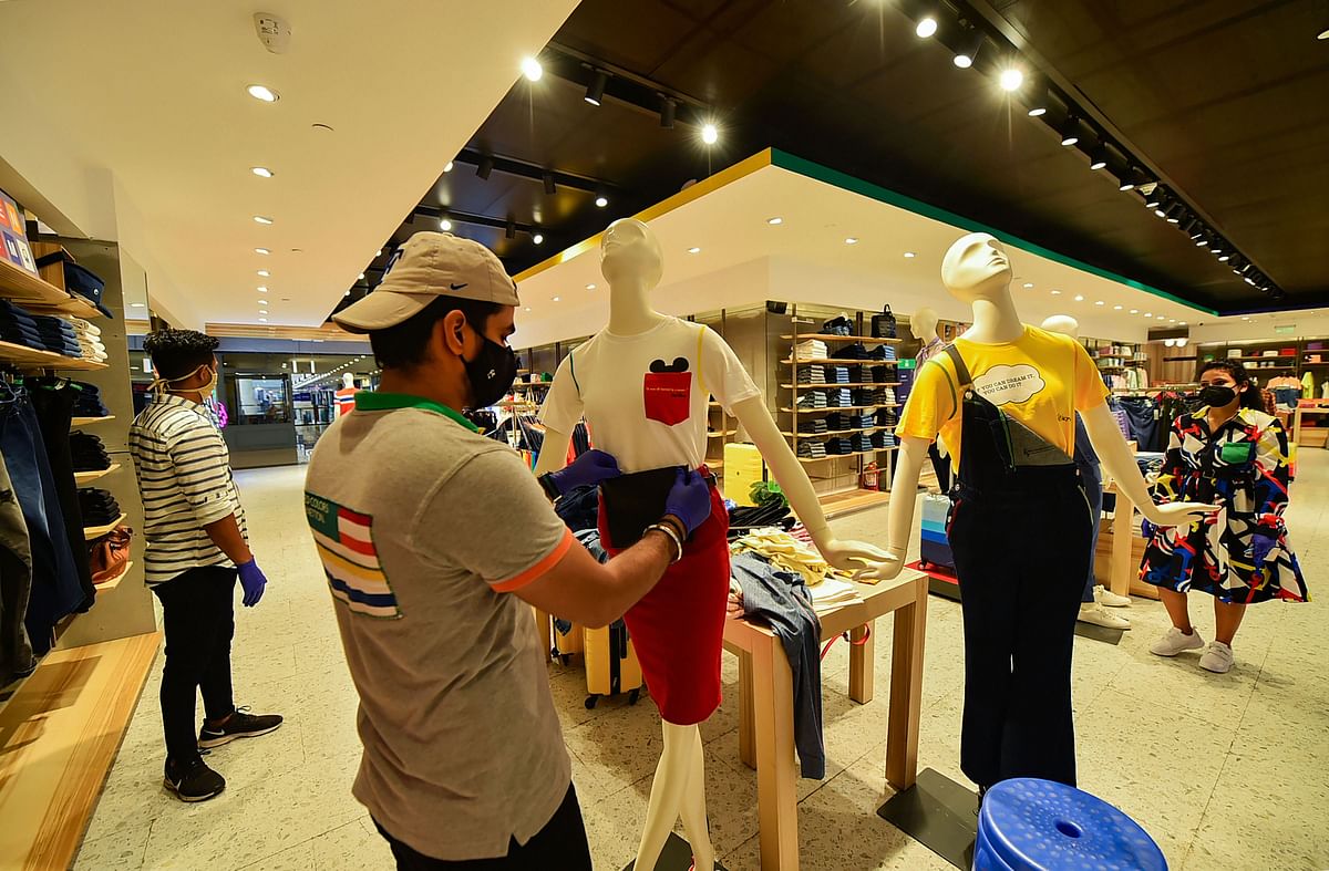 A salesperson wearing a mask places a mannequin on display at a garment store inside Select Citywalk after the authorities permitted to reopen malls, in New Delhi, Monday, June 8, 2020. Malls and shopping centers in the national capital re-open on Monday after more than two months, focussing on hourly disinfection of the common areas, contactless shopping, and physical distancing to prevent the spread of the deadly coronavirus. Credit: PTI Photo