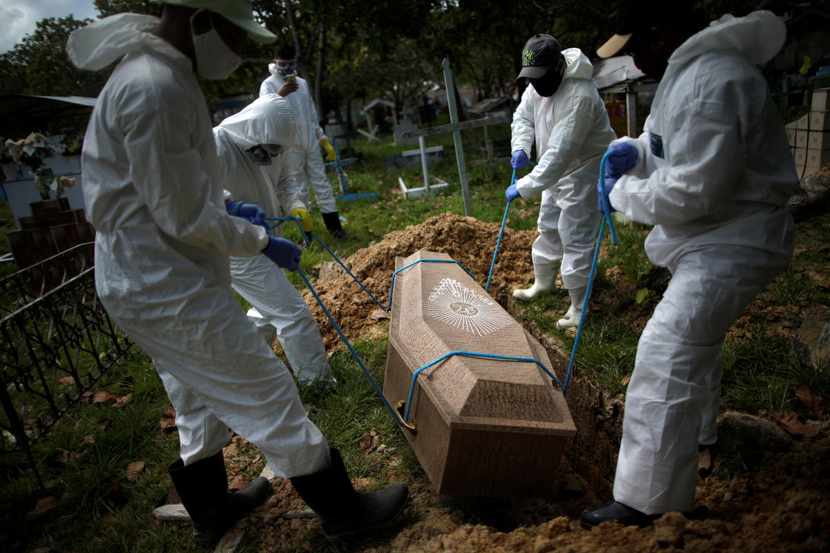 Gravediggers wearing protective suits bury the coffin of 70-year-old Manuel Farias, who died from the coronavirus disease (COVID-19), at Recanto da Paz cemetery, in Breves, southwest of Marajo island in Para state, Brazil. Credit/Reuters Photo