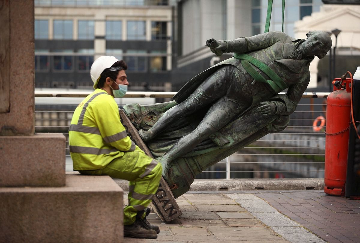 A worker rests after the statue of slave owner Robert Milligan was taken down, at West India Quay, east London. Credits: AFP Photo