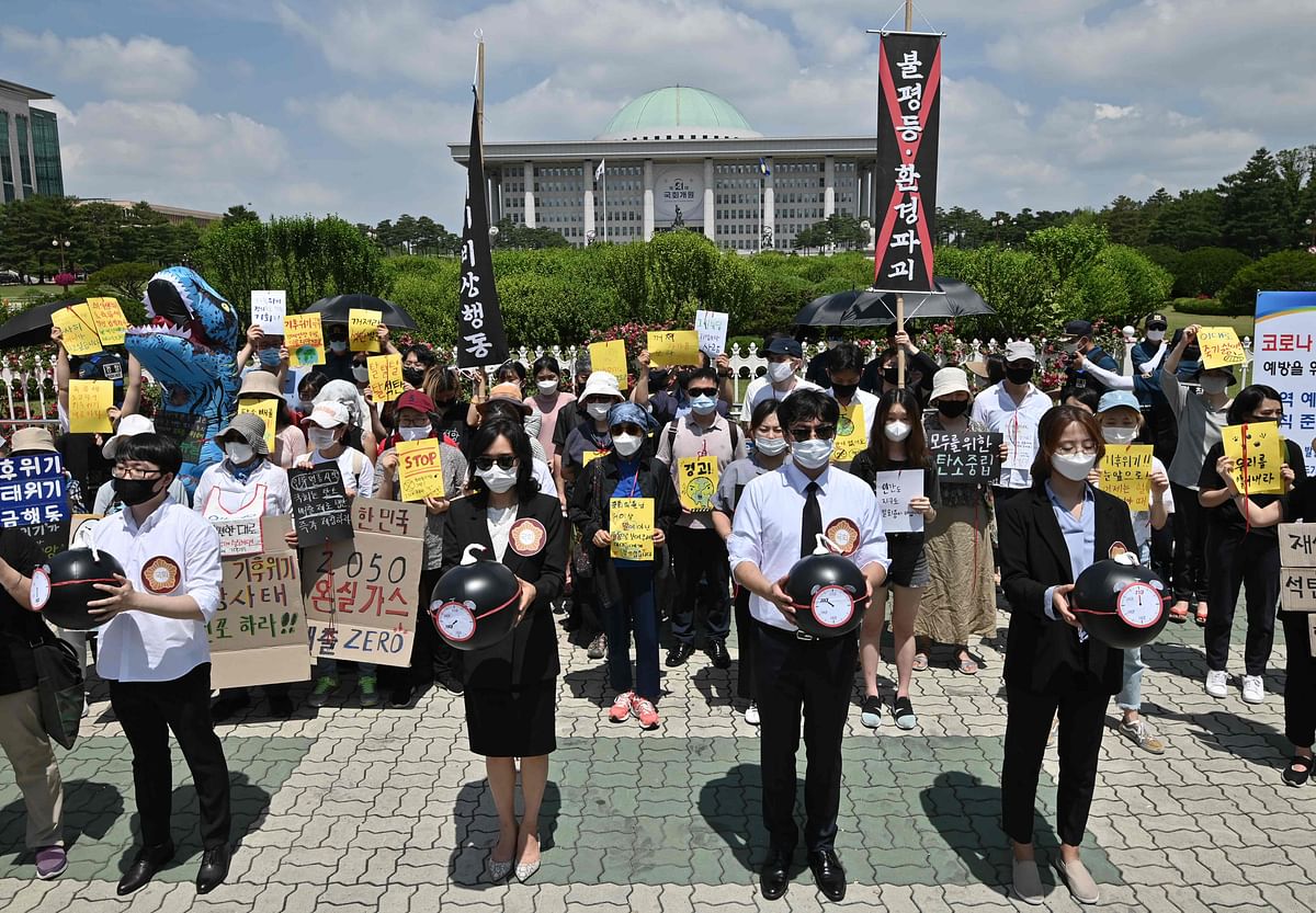 South Korean environmental activists hold mock time bombs during a rally urging the newly opened parliament to establish bills on climate crisis, in front of the National Assembly in Seoul. Credit: AFP Photo