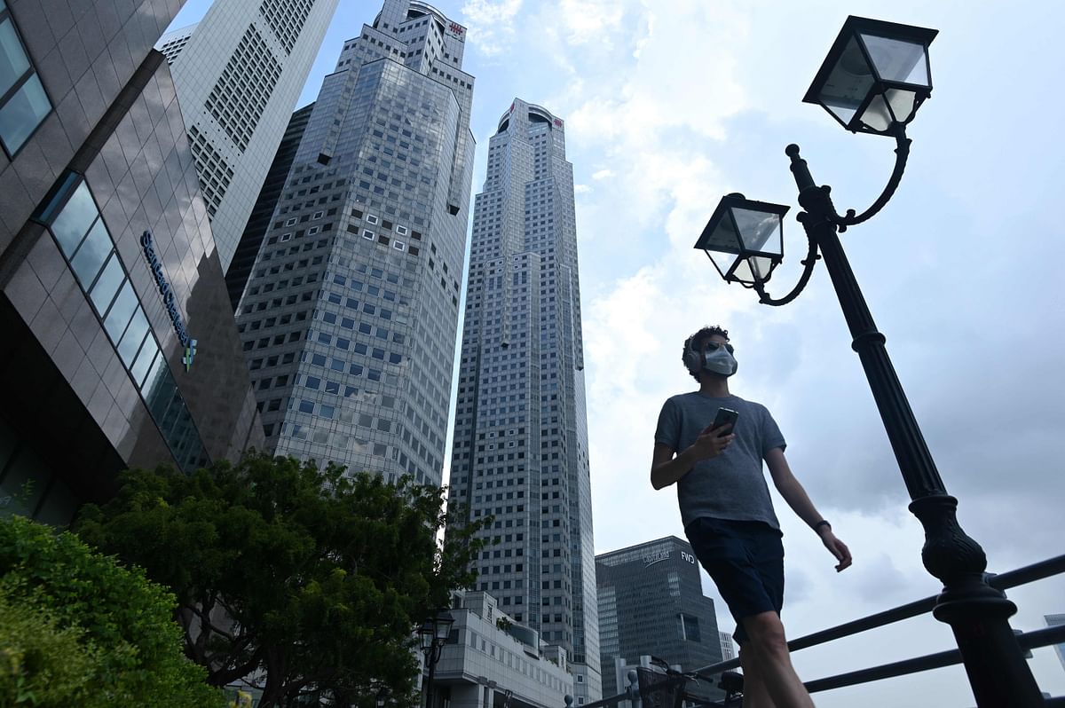 A man walks past commercial buildings in the financial business district in Singapore on June 11, 2020, as the city state eased its partial lockdown restrictions aimed at curbing the spread of the COVID-19 coronavirus. Credit: AFP Photo