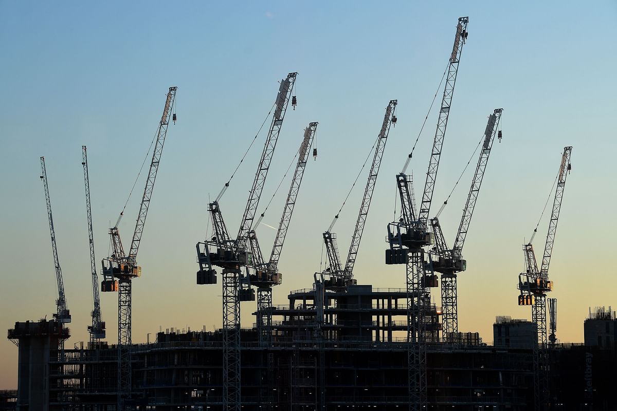 In this file photo taken on May 14, 2020 The sun sets beyond construction cranes standing over the building site for new apartments and a retail complex, at the Battersea Power Station redevelopment site in south London. Credit: AFP Photo