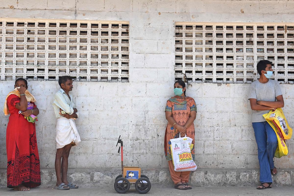 Indian engineer Karthik Velayutham (not pictured) uses his robot in a queue to wait for his turn outside a ration shop in Coimbatore. - The robot has been self designed by Velayutham, from the southern district of Tamil Nadu. Credits: PTI Photo