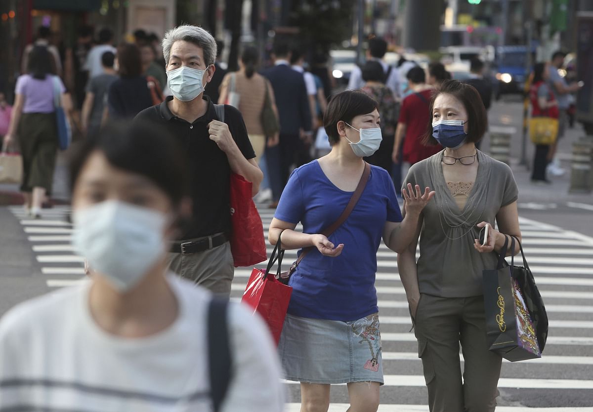 People walk through the streets of downtown Taipei, Taiwan, wearing face masks help curb the spread of the coronavirus in Taipei, Taiwan. Credit: AP Photo