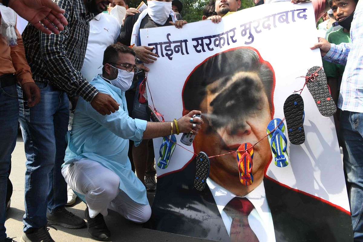 Activists of Bharatiya Janata Party (BJP) spray black paint on a poster depicting Chinese President Xi Jinping during an anti-China protest in Amritsar. Credits: AFP Photo