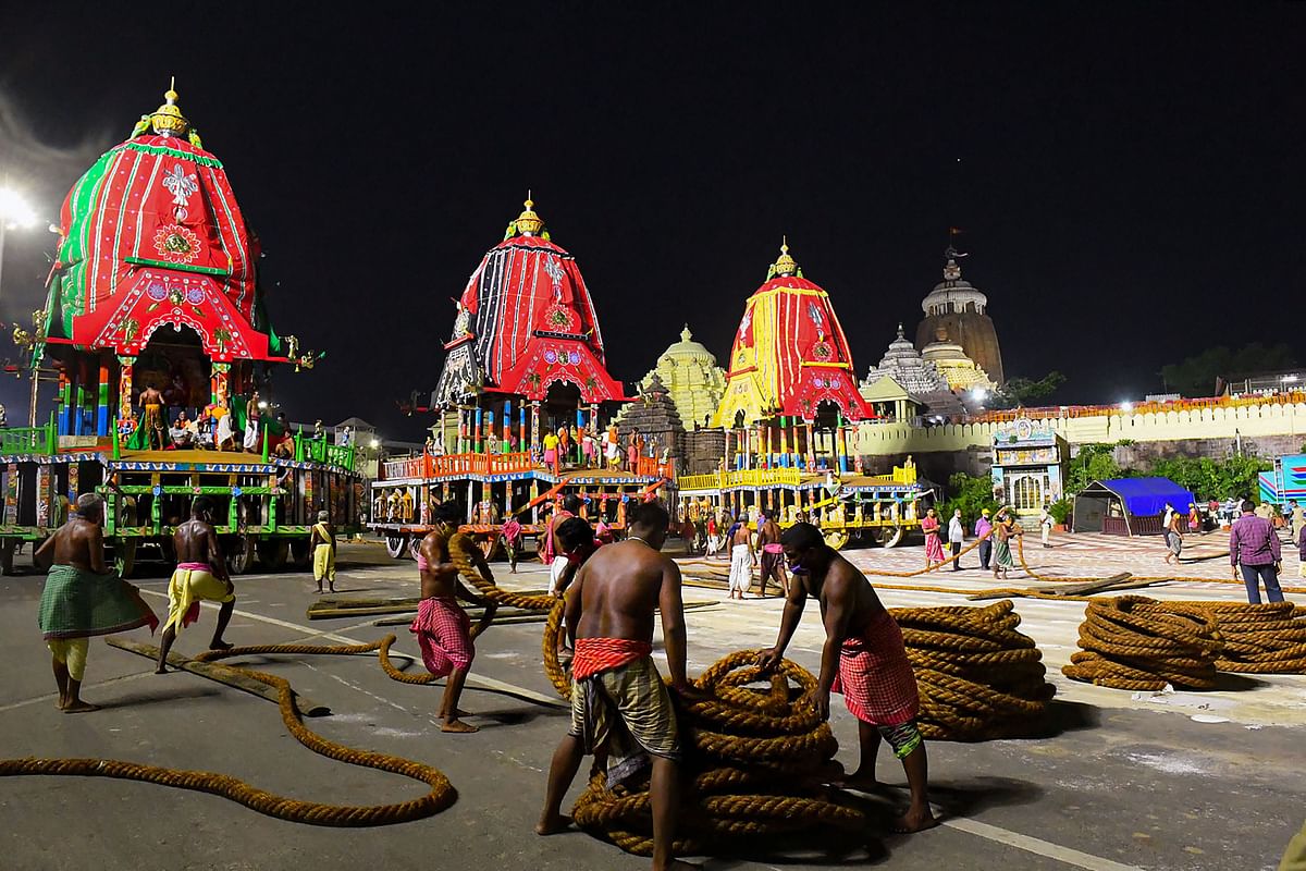 Workers preparing to pull the three chariots of Lord Jagannath, Balarama, and Subhadra from the construction site (Ratha Khala) to Jagannatha Temple for the annual Rath Yatra, scheduled to start from tomorrow, in Puri. Credits: PTI Photo