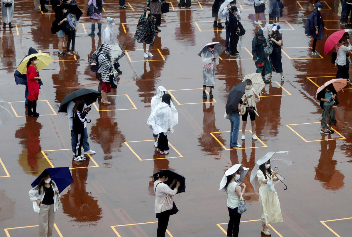Visitors practice social distancing while waiting to enter the park in the poor weather during the reopening of Tokyo Disneyland along with Tokyo DisneySea, which closed for months due to the coronavirus disease (COVID-19) outbreak, at the entrance gate of Tokyo DisneySea in Urayasu, east of Tokyo, Japan. Credit/Reuters Photo