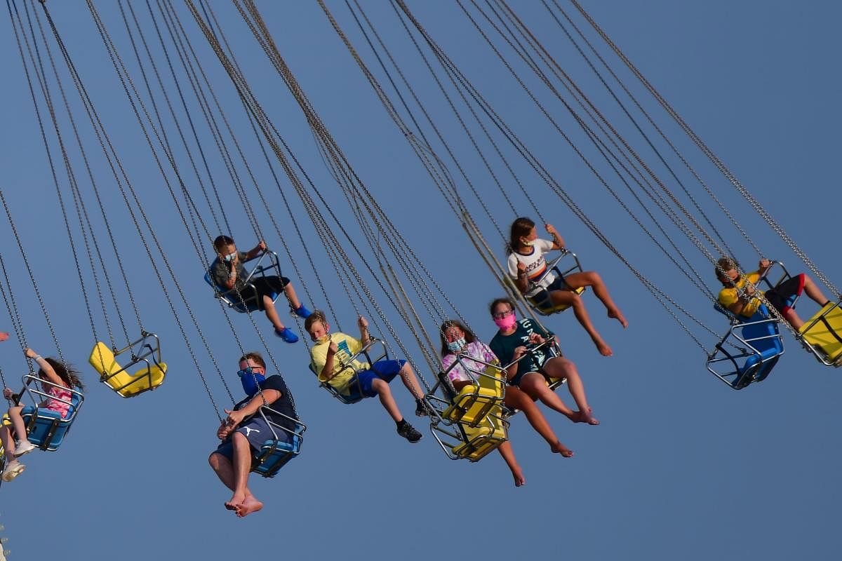 People wearing masks ride attractions at an amusement pier on July 3, 2020 in Wildwood, New Jersey. New Jersey beaches have reopened for the July 4th holiday as some coronavirus restrictions have been lifted. Mark Makela/Getty Images/AFP