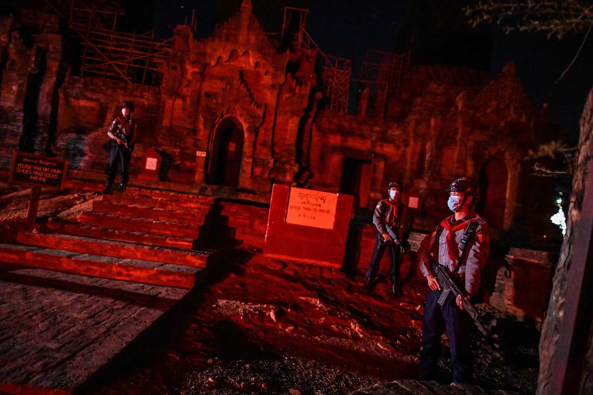 Members of a police squad standing guard outside a temple complex in Bagan, Mandalay Region. - A squad of gun-toting police patrol Myanmar's sacred site of Bagan under the cover of night. Credits: AFP Photo