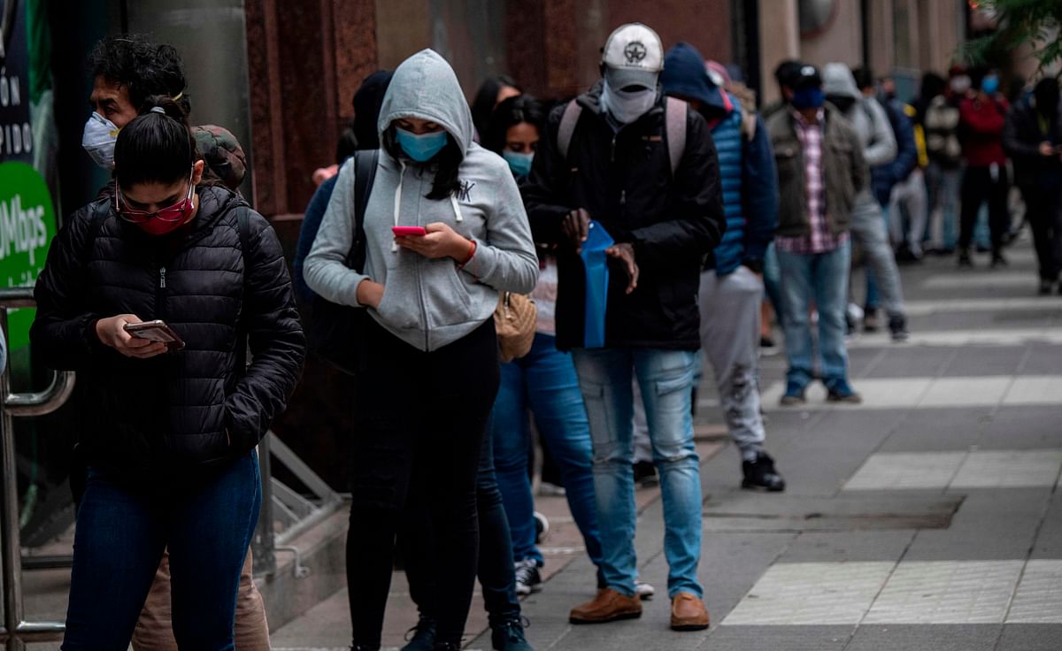 People wear face masks as they queue to get an unemployment insurance outside the Chilean Unemployment Funds Administration headquarters in Santiago. Credits: AFP Photo