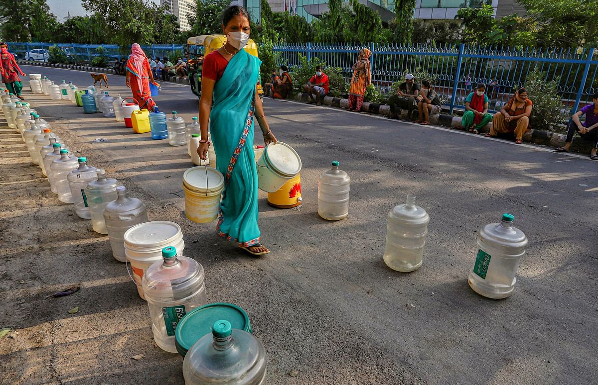 Residents of Chilla village place containers in queues to reserve their spot while waiting to collect water from a tanker of Delhi Jal Board, in New Delhi. Credits: PTI Photo