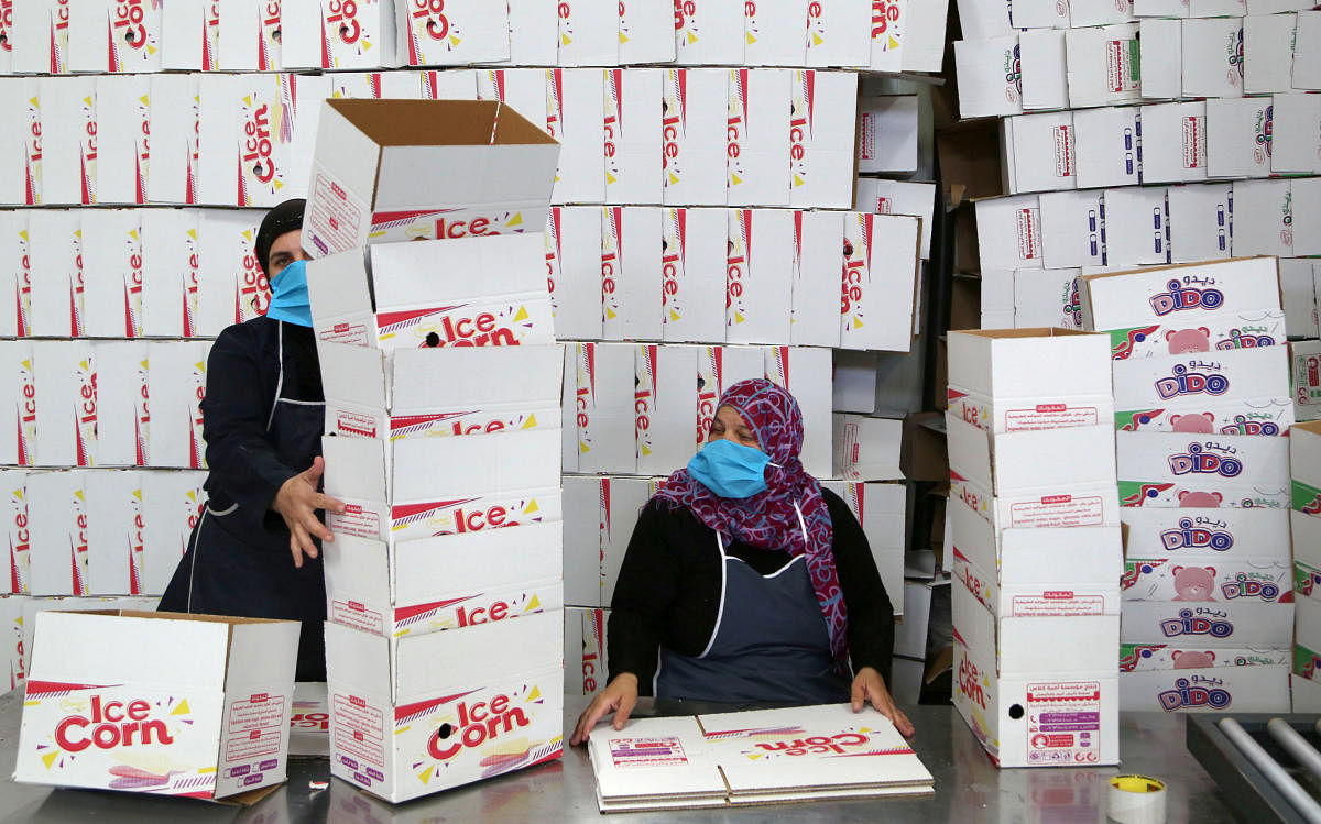 Workers arrange boxes to be filled with ice cream inside an ice cream factory in Damascus, Syria. Credit: Reuters