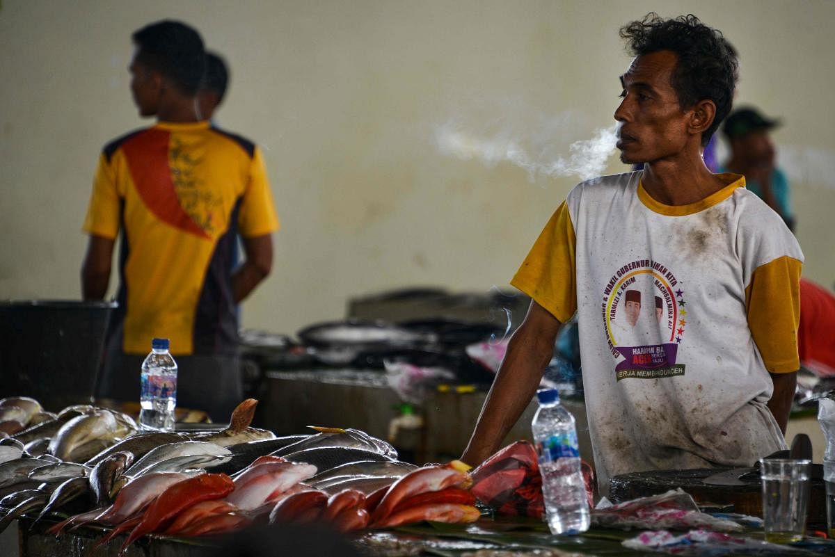 A man waits for customers at a fish market in Banda Aceh on July 7, 2020. Credit: AFP