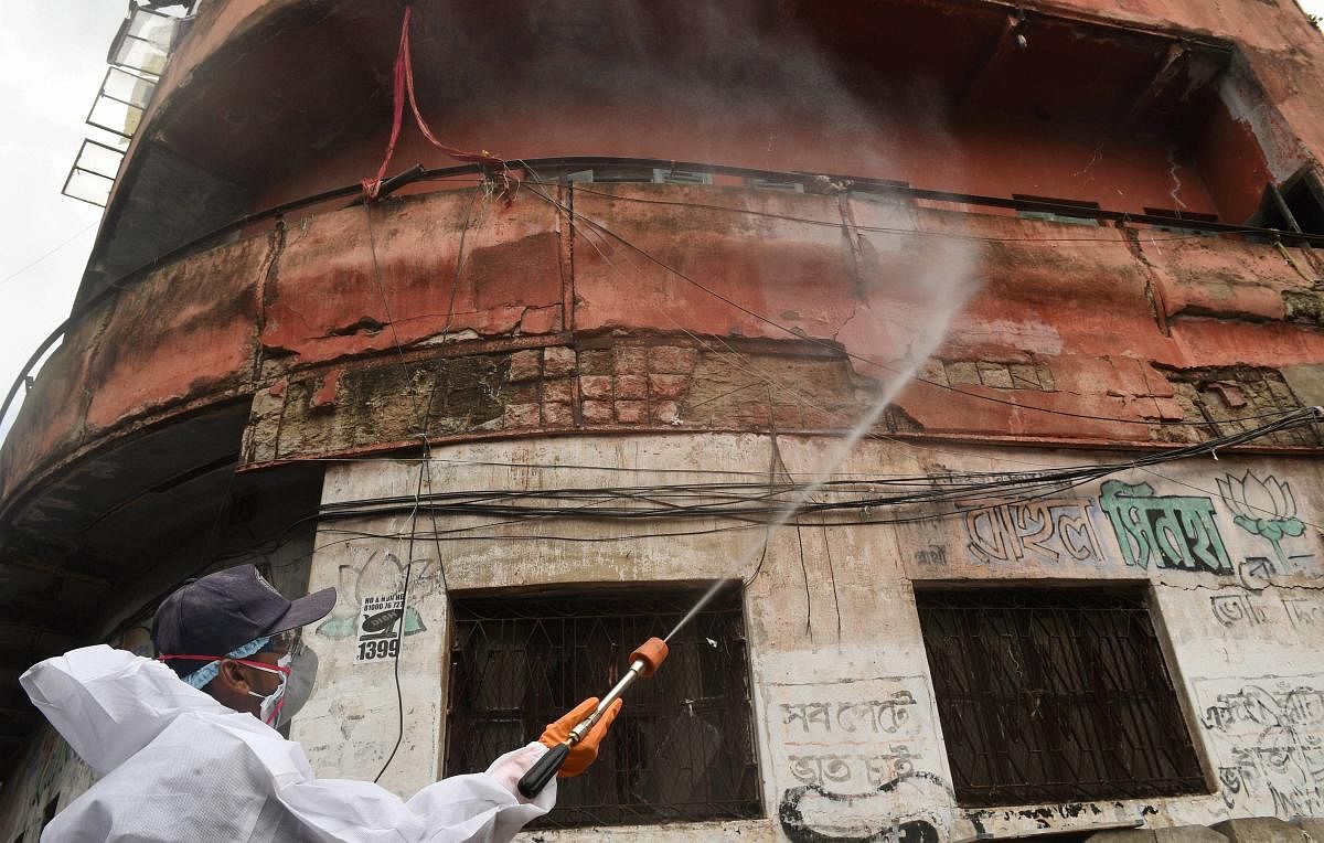 A KMC worker sprays disinfectant outside a sealed residential complex following emergence of Covid-19 cases, during Unlock 2.0 (PTI Photo)