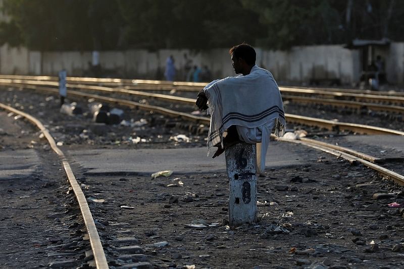 A man sits on a milestone along a railway track at a slum area as the outbreak of the coronavirus disease (COVID-19) continues, in Karachi, Pakistan. Credits: Reuters Photo
