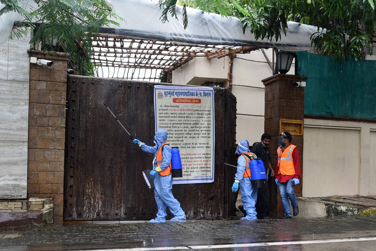 Civic authority workers spray sanitiser on the main door of the residence of Bollywood star Amitabh Bachchan as he tested positive for Covid-19 in Mumbai. Credits: AFP Photo
