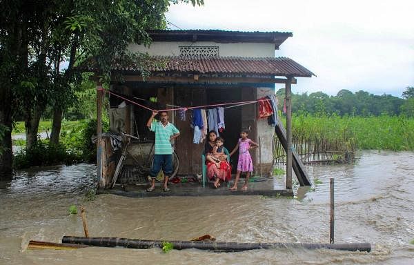A flood affected family takes shelter at a shop at Manahkuchi near Hajo in Kamrup district of Assam, Sunday, July 12, 2020. Credit: PTI Photo