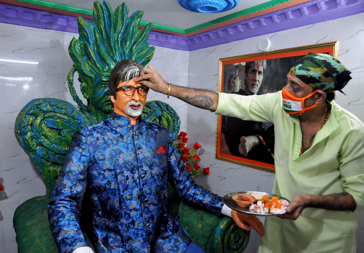 A member of All Bengal Amitabh Bachchan Fans' Association offers tilak on his statue while worshiping for his speedy recovery after he tested positive with coronavirus. Credits: PTI Photo