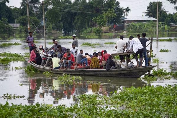 Villagers cross a flooded area on a boat, at Buraburi village in Morigaon district, Wednesday, July 1, 2020. Credit: PTI Photo