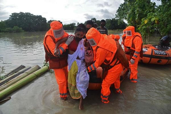 National Disaster Response Force (NDRF) personnel carry a sick woman during a rescue operation in a flood affected area due to monsoon rains, in Pathsala of Barpeta district, some 105 kms from Guwahati, the capital city of India’s northeastern state of Assam on July 12, 2020. Credit: AFP Photo