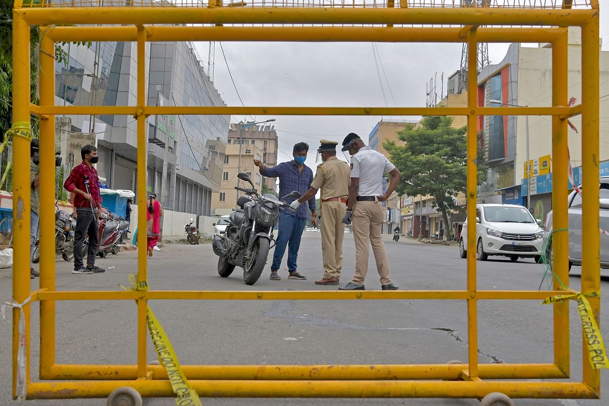 Policemen stop a motorist at a check post during a week-long lockdown to contain the surge of COVID-19 coronavirus cases, in Bangalore. Credits: AFP Photo